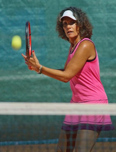 Women in a pink dress playing tennic